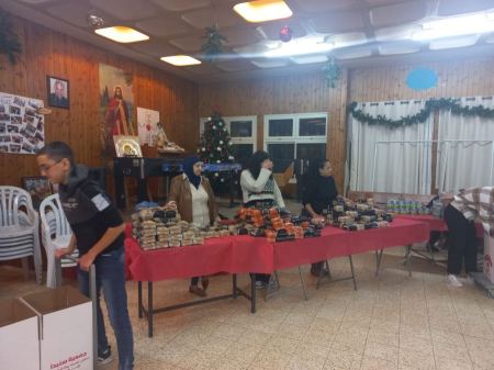 طاقم "هات" يبث روح العطاء والبهجة ويساعد بتوزيع الطرود الغذائية بمناسبة الميلاد المجيد